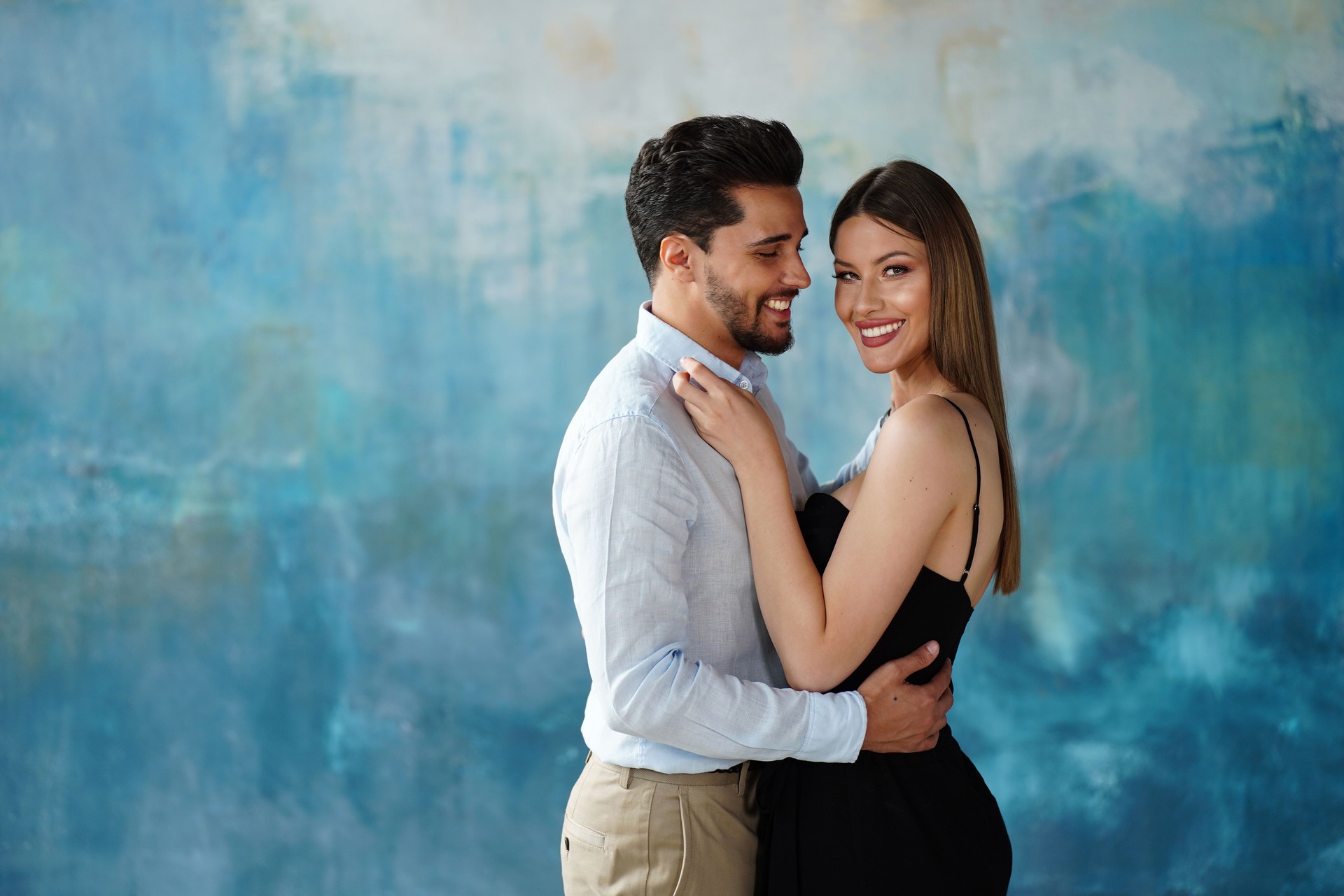 Stylish young elegant couple posing together, hugging and smiling. Elegant style. Date. Real people emotions